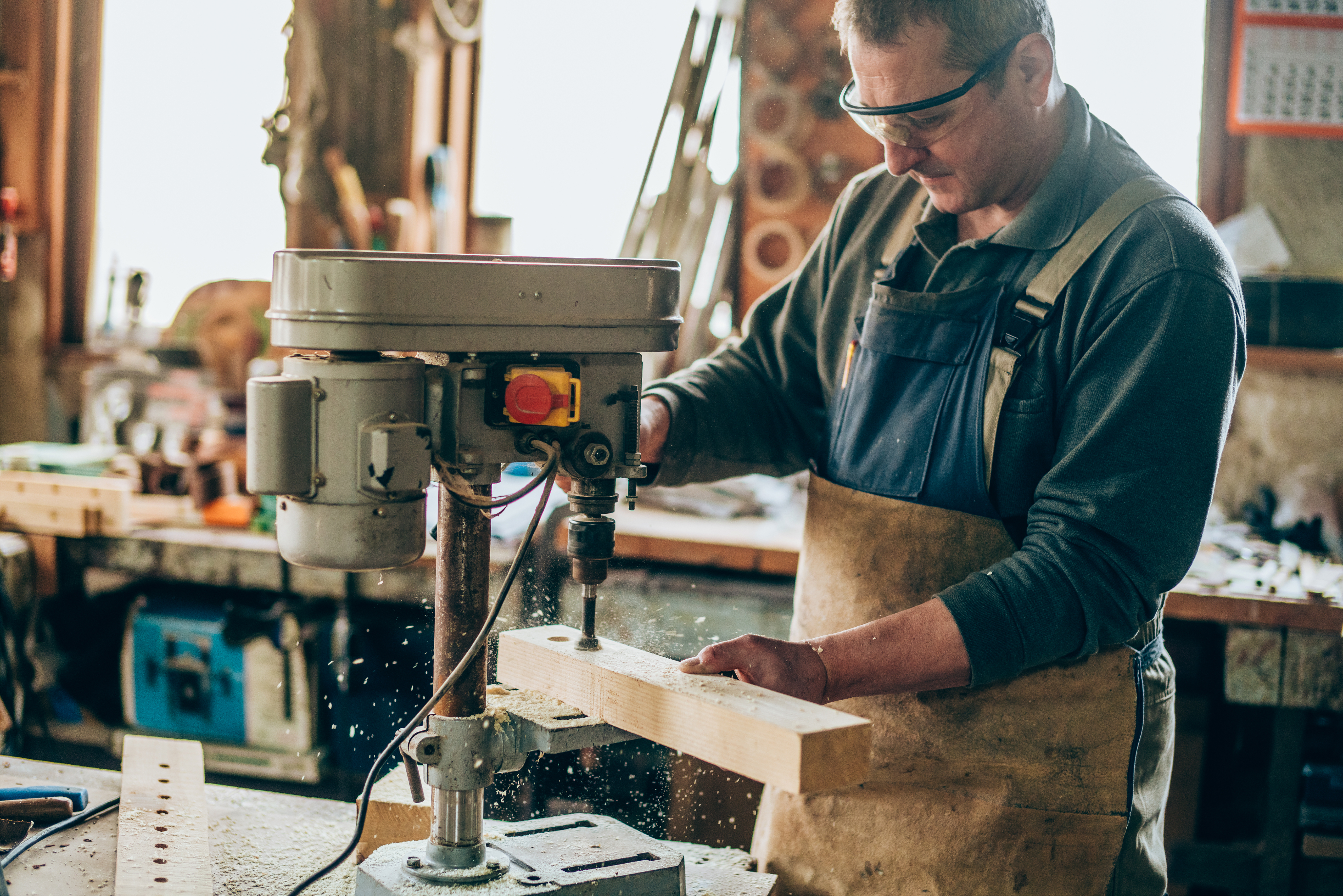 man drilling into a piece of wood