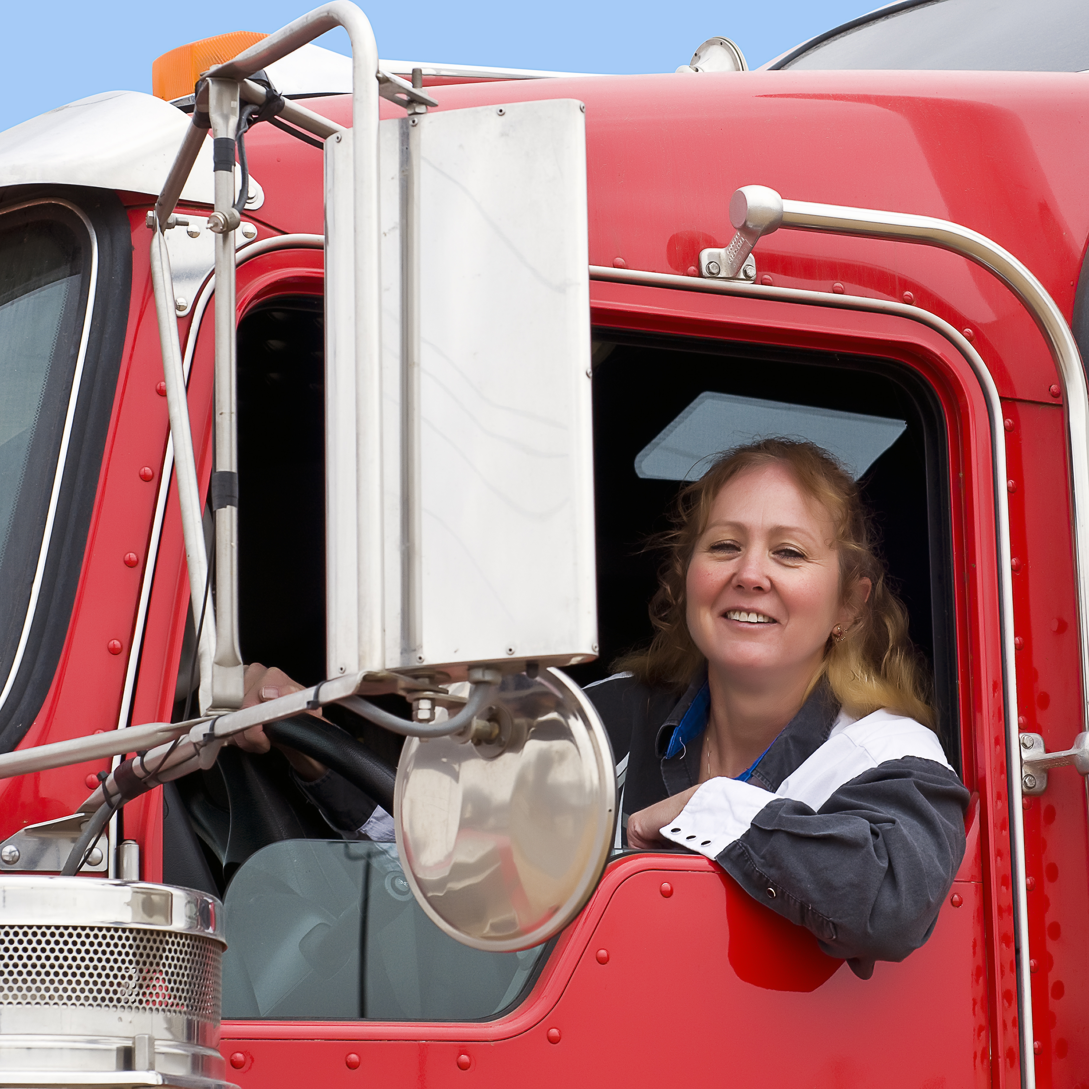 Woman truck driver looking out of a semi-truck while driving