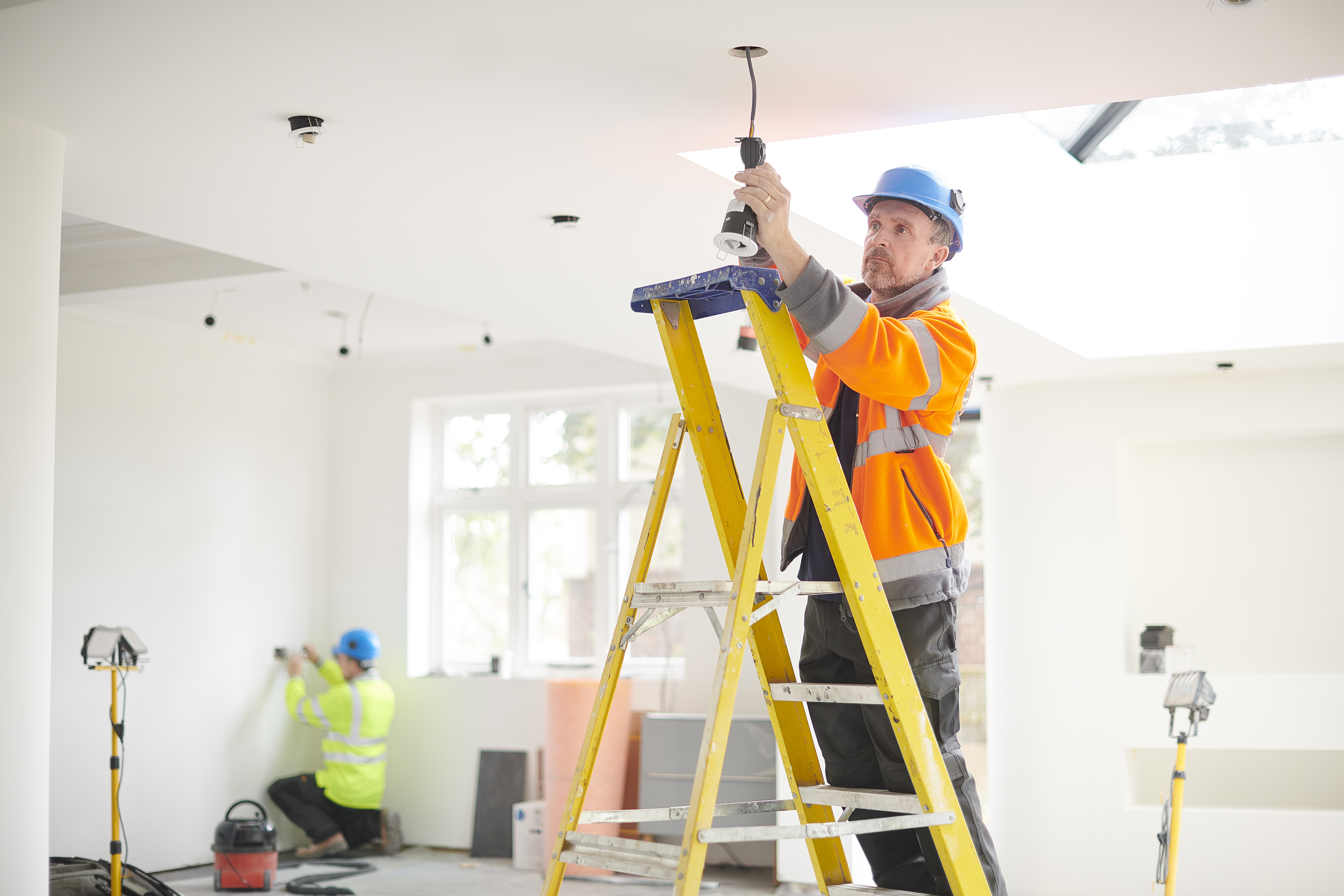 electrician installing downlights
