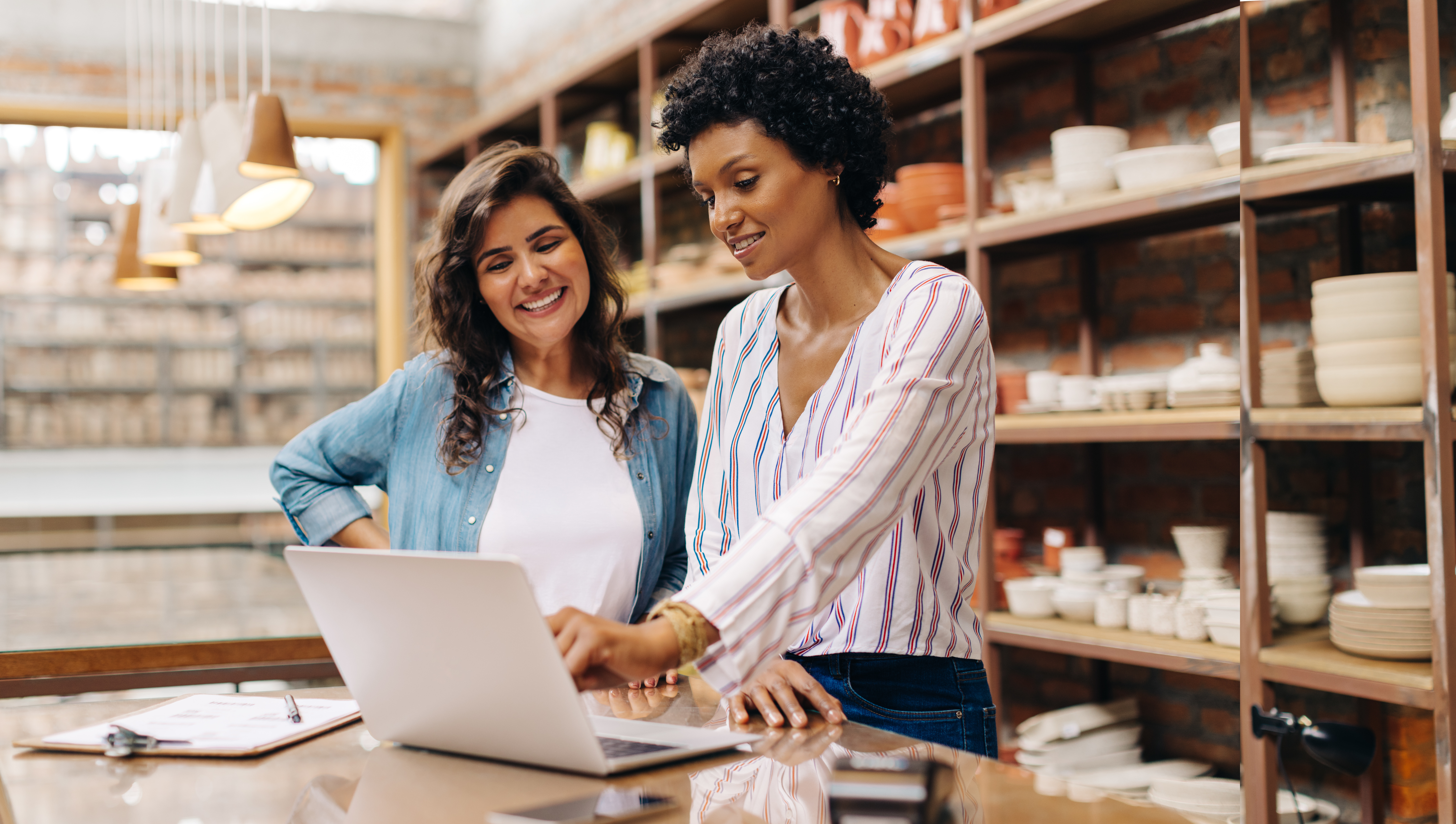 Two women look at a laptop